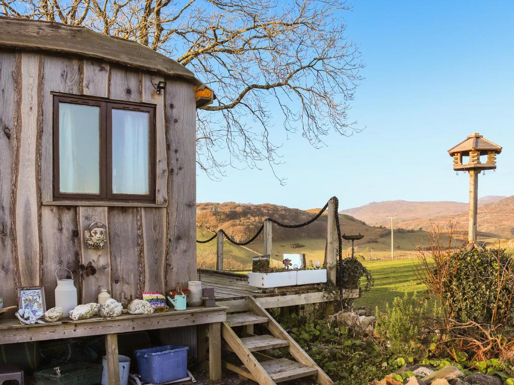 a wooden shed with a table and a bird house at The Peacock Roost - Uk46297 in Brynkir