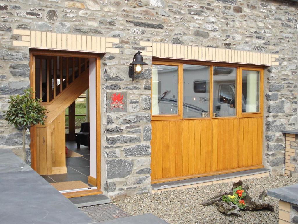 a stone house with a wooden door and windows at Bwthyn Celyn-Oa6 in Ystrad Meurig