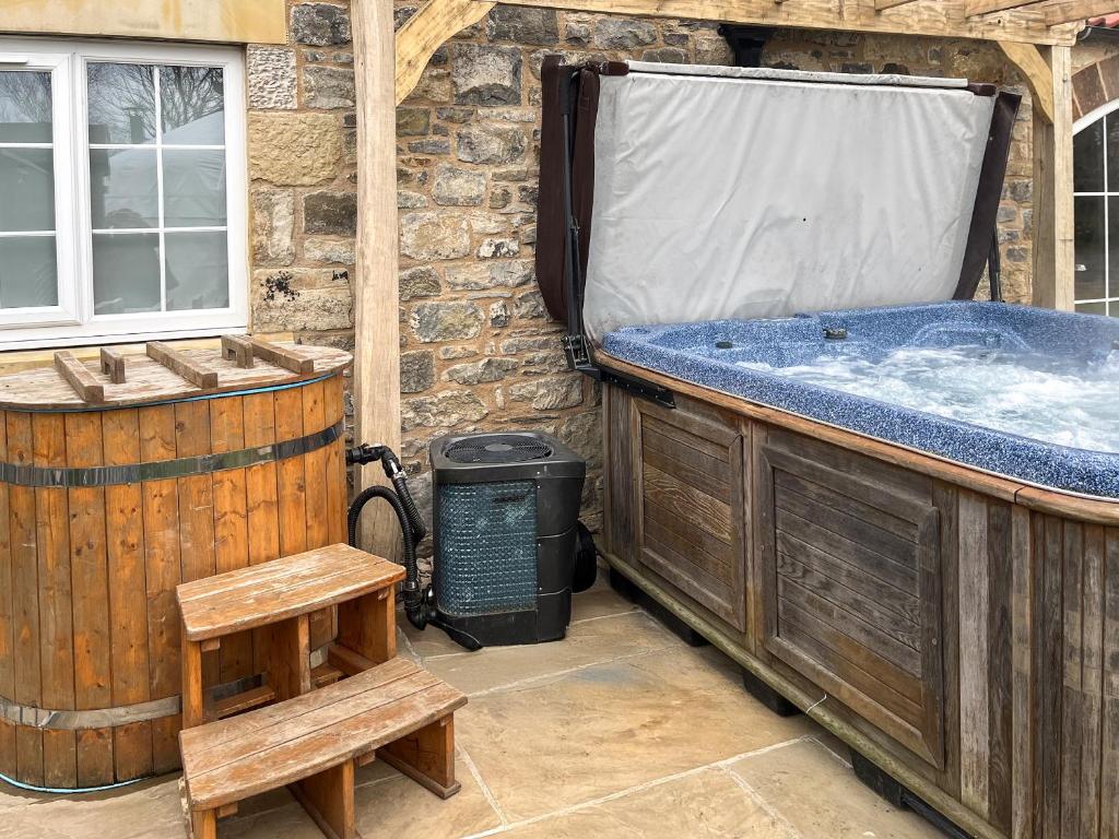 a hot tub and a bench next to a building at Ember Sky Yurt - Uk51679 in Beadnell