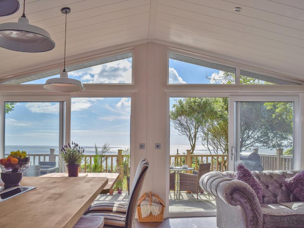 a dining room with a table and some windows at Seacliff in Corton