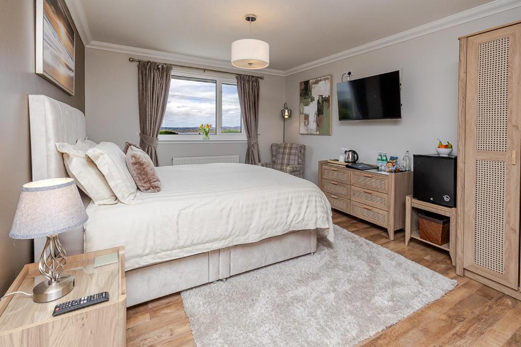 a bedroom with a large bed and a television at Seaview Bed & Breakfast in Isle of Lewis