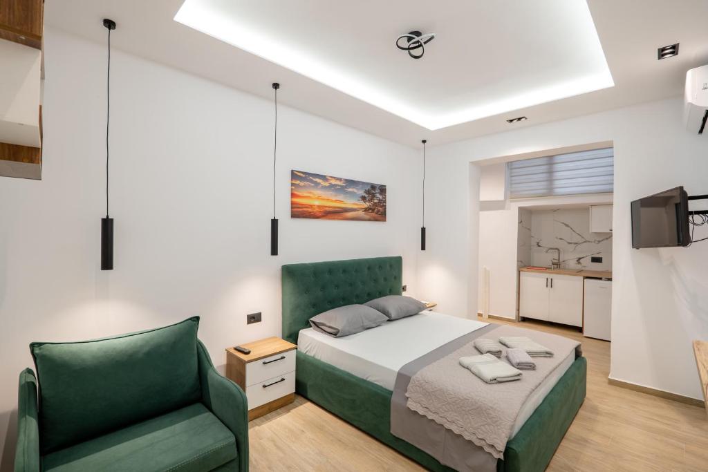 a bedroom with a bed and a green chair at Villa Bella in Ksamil