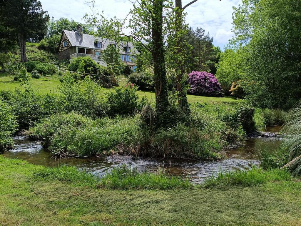 a house and a stream in front of a house at Gite Le Clos de Sée in Chérencé-le-Roussel