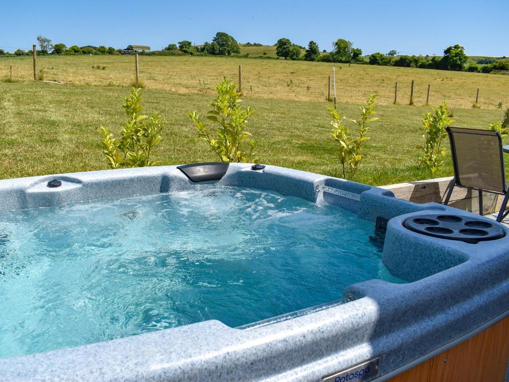 a hot tub with a chair in a field at Whitey Top Country Lodge in Pentridge