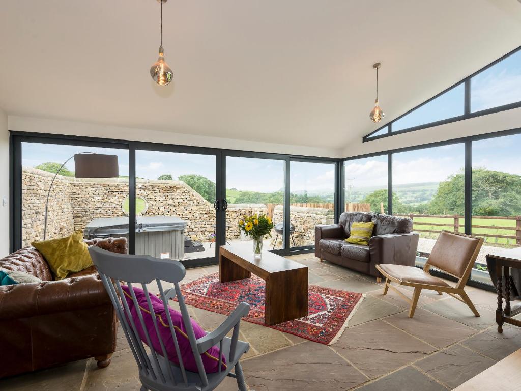 a living room filled with furniture and a lot of windows at Moorgate Cottage - Ukc3380 in Kelbrook