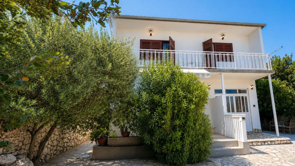 a white house with trees in front of it at MAG Apartmani in Jezera