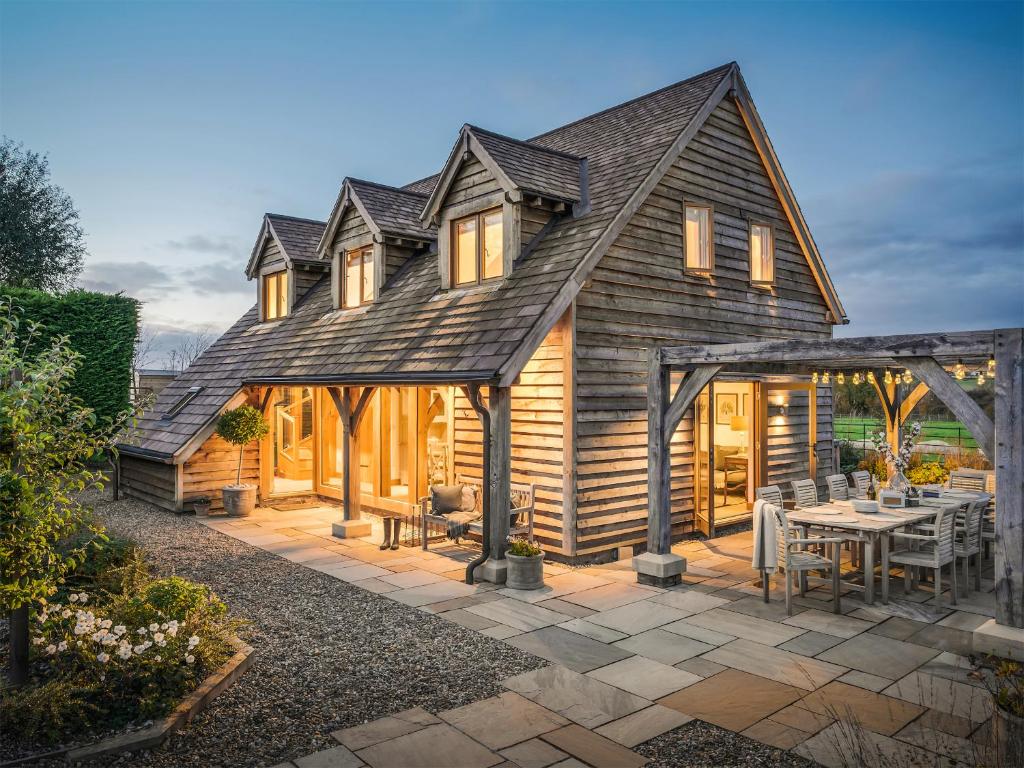 a large wooden house with a patio at Hare's Furrow - Uk12607 in Burton Overy