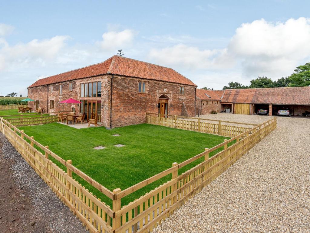 a large brick building with a grass yard in front of it at The Vintage Store - Uk32652 in Elston
