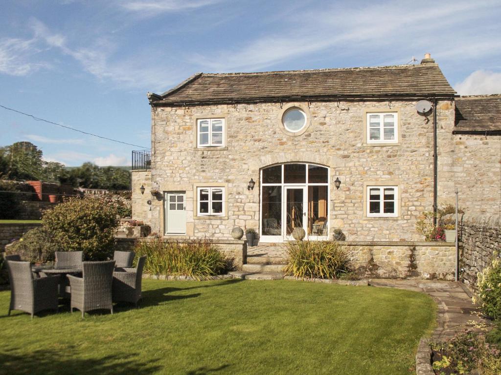 a stone house with a lawn in front of it at Flatts Barn in Hebden