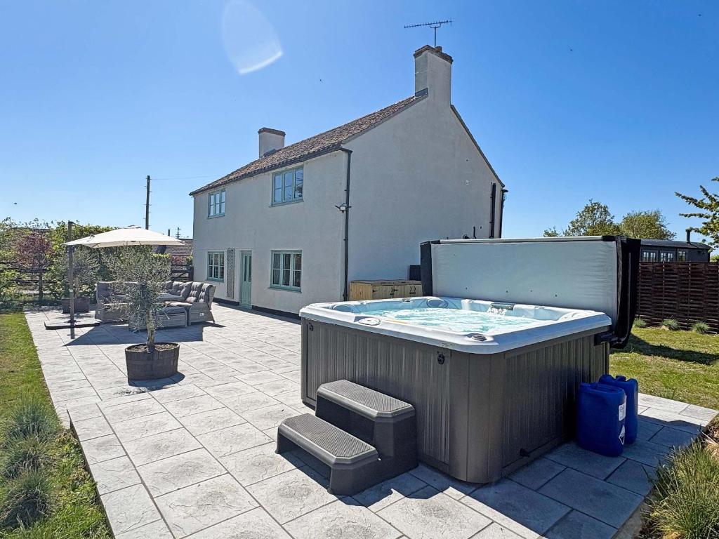 a hot tub on a patio in front of a house at Hill House - Uk49727 in King's Lynn