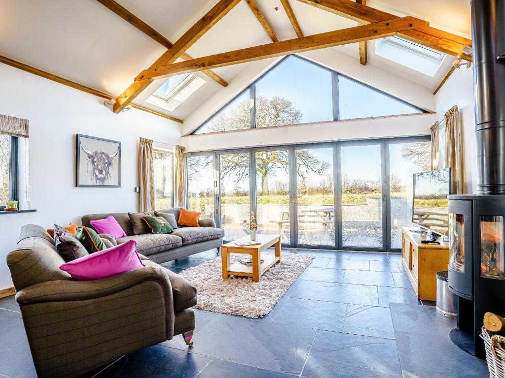 a living room with couches and a large window at Y Glowty Newydd - Uk31701 in Llandissilio
