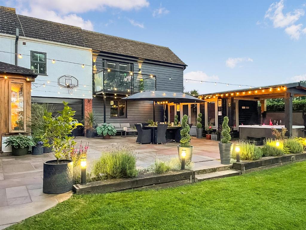 a patio with lights in the yard of a house at Myrtle Cottage in Potter Heigham