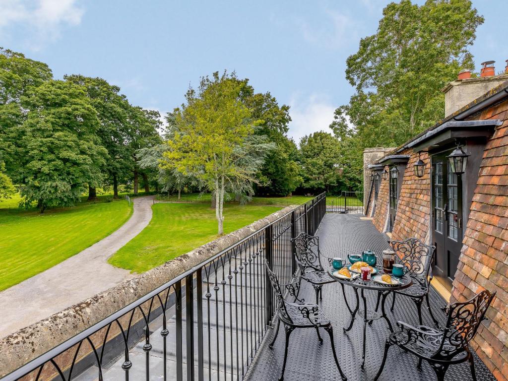 a balcony with a table and chairs on a fence at Eagles Nest At Greyfriars - Uk33356 in Winchelsea