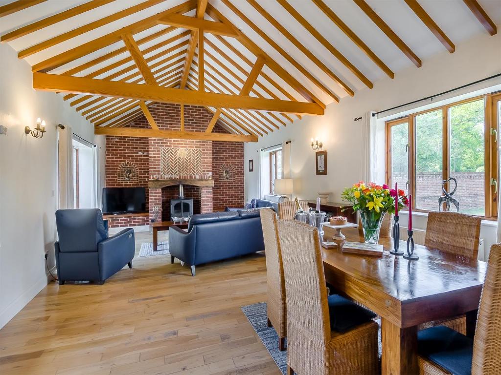 a living room with a wooden table and a dining room at Beech Barns - Czu in Neatishead