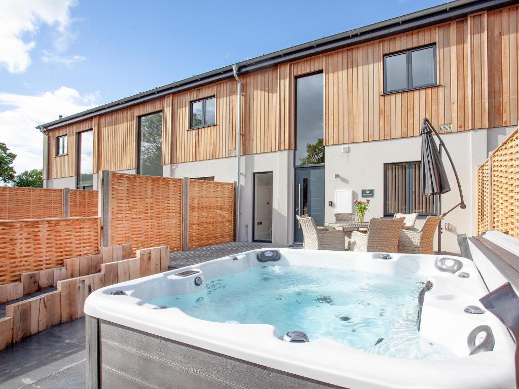 a hot tub on the patio of a house at Primrose-Uk34614 in Nether Stowey
