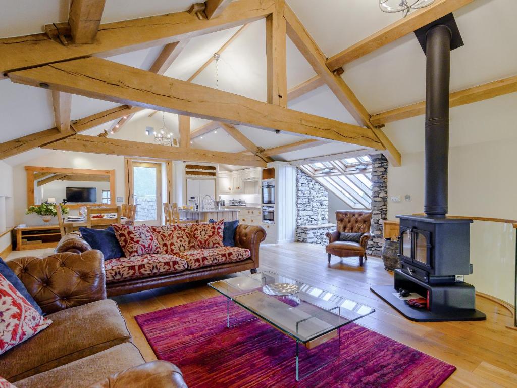 a living room with a couch and a stove at Mungeon Barn - Uk30125 in Backbarrow