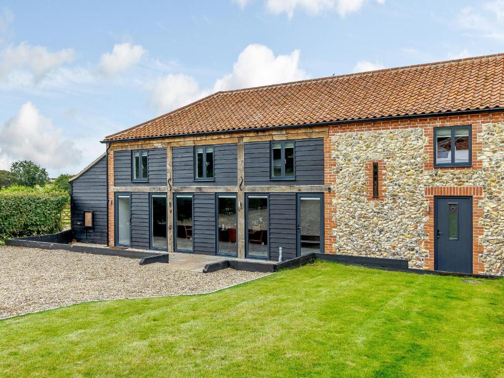 an external view of a stone building with a yard at Kestrel Barn-Uk31353 in Swaffham