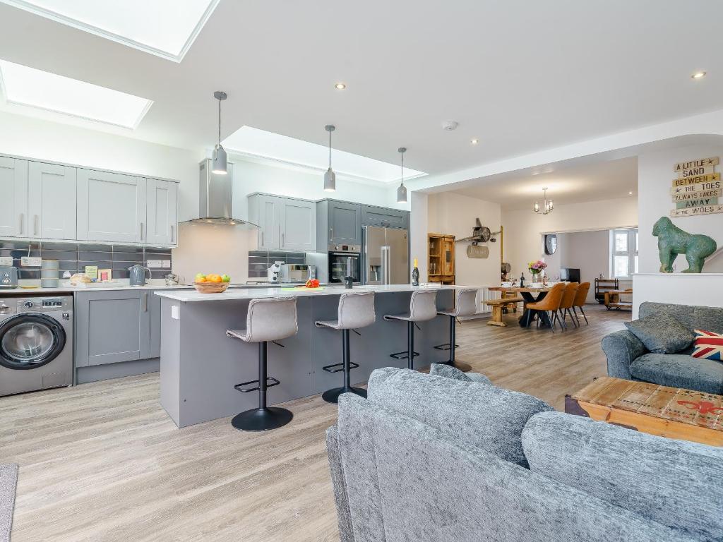a kitchen and living room with two couches and a kitchen and a living room at Wynbec Cottage in Esh