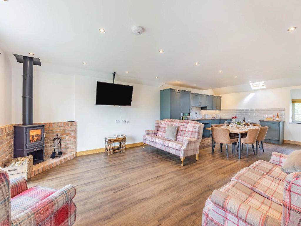 a living room with a fireplace and a dining room at The Old Stables - Uk37000 in Ridlington