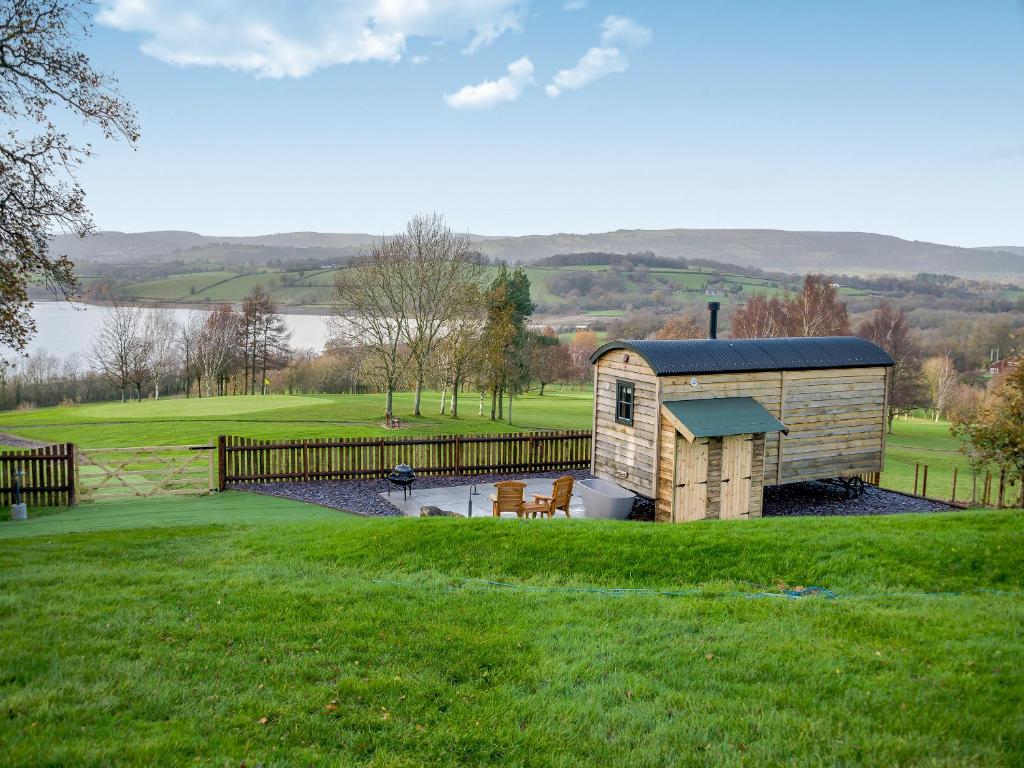 a building in the middle of a field with a fence at Hut Uk42176 in Usk