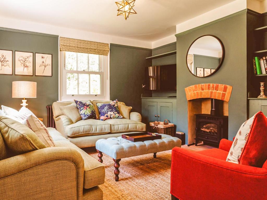 a living room with two couches and a fireplace at Gatehouse North in Worstead