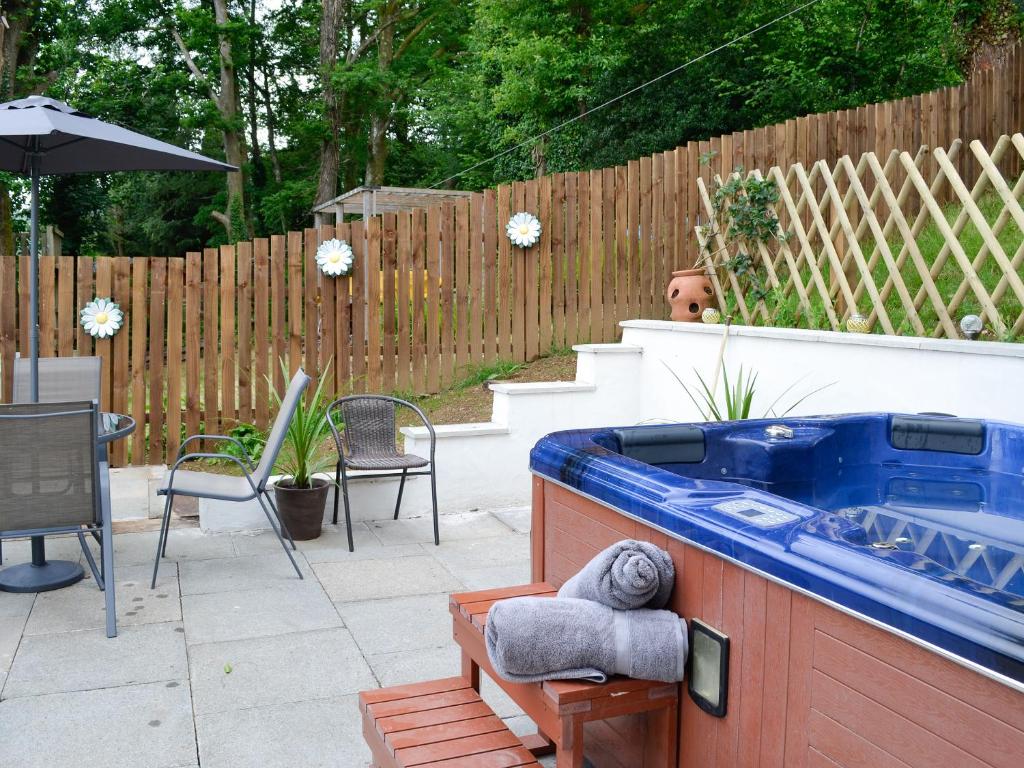 a large blue tub in a backyard with a fence at Bryn Aled in Llanfachreth