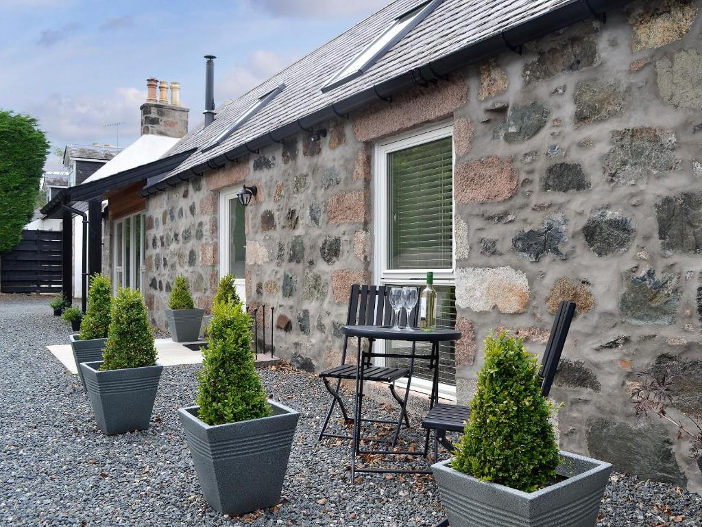 a stone house with plants in front of it at Longcroft Dairy in Oyne