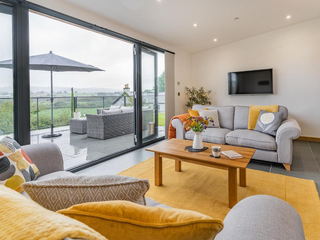 a living room with a couch and a table at Cwtch Ty Gwyn in Llandeilo