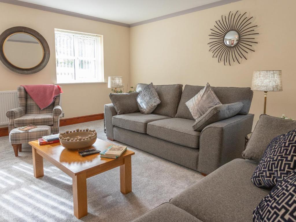 a living room with a couch and a table at Sycamore Cottage-Uk2785 in Penmaen-mawr