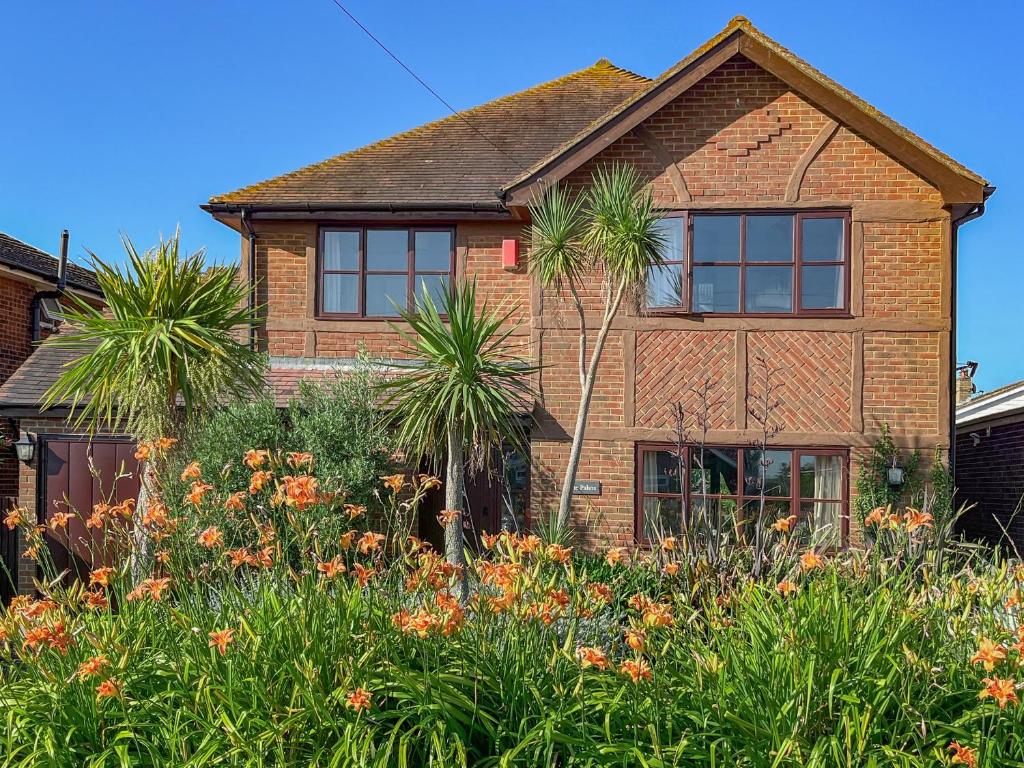 a brick house with palm trees in the yard at The Palm in Seasalter