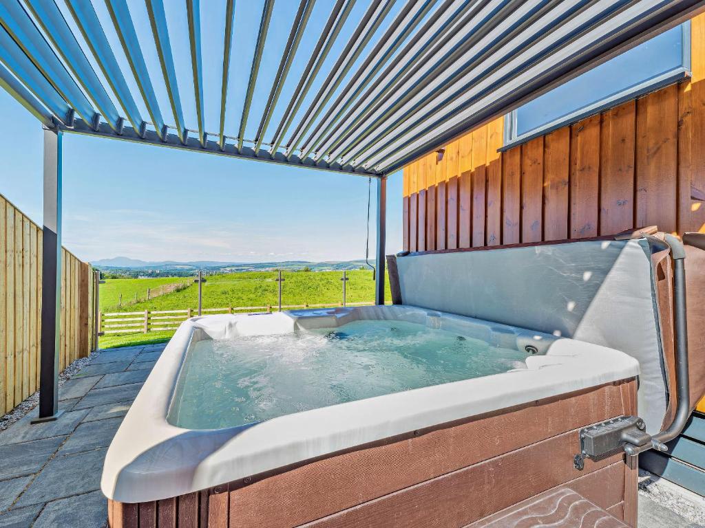 a jacuzzi tub on a deck with a view at Glencoe Luxury Lodge in Erskine