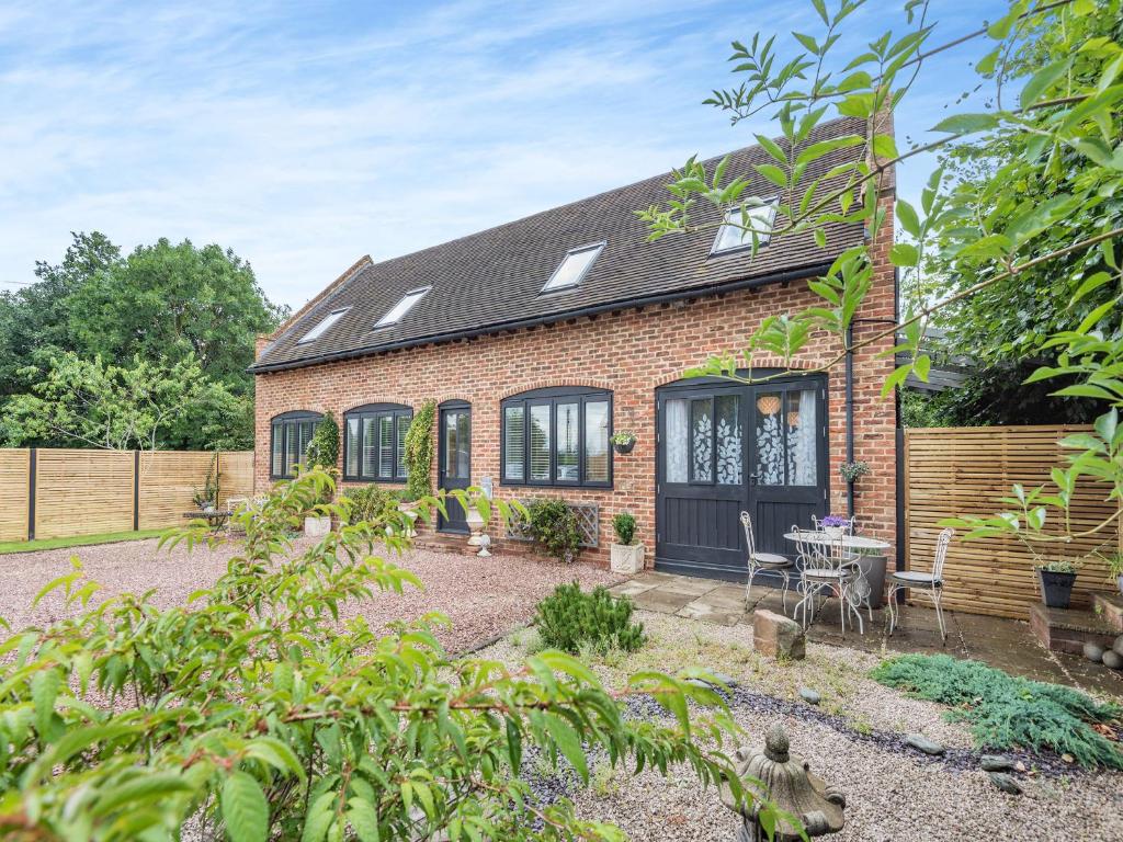 a brick house with a table and chairs in a yard at Dower House Lodge in Ludlow