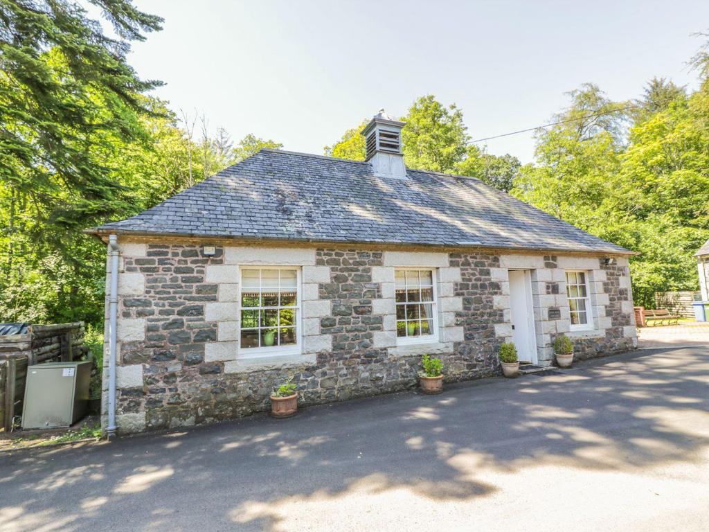 an old stone house with potted plants in front of it at Duck Pond- Uk7232 in Kirkmichael