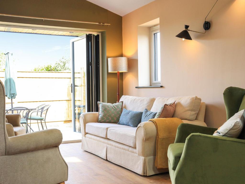 a living room with a white couch and chairs at The Watertower in Marlborough