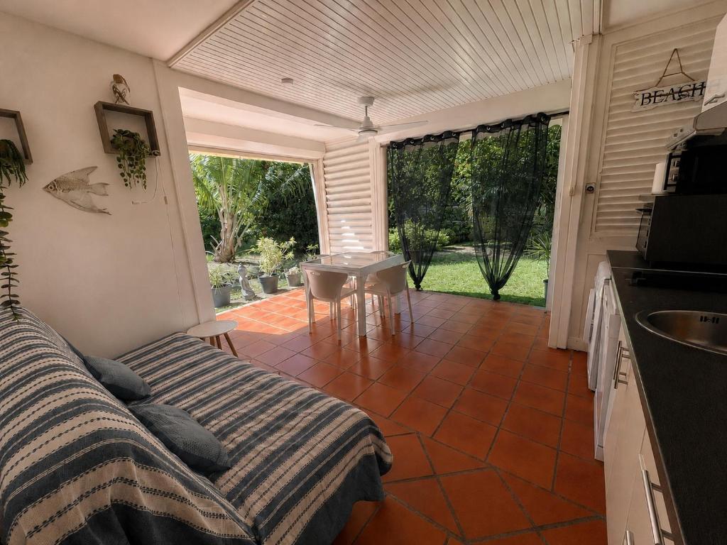 a room with a bed and a kitchen with a table at Ti coin de paradis Anse des Rochers in Saint-François