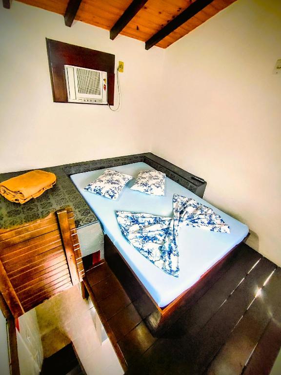a bed in a room with a table and a chair at Pousada Em Busca do Sol in Trindade