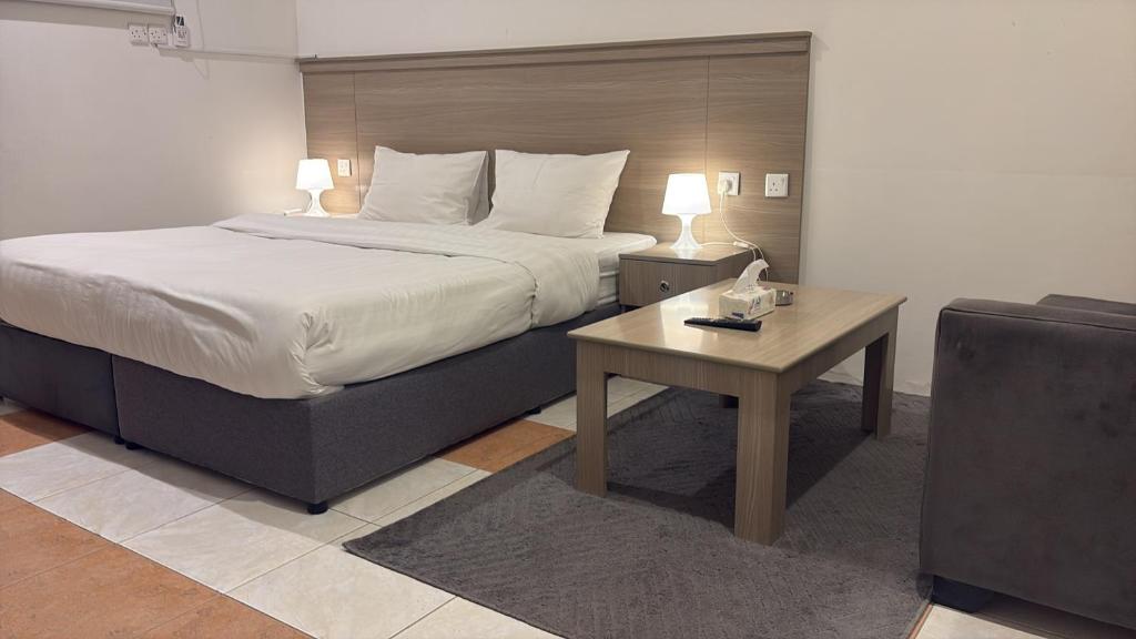 a bedroom with a bed and a table and a couch at شقق وردة الخرج in Al Kharj
