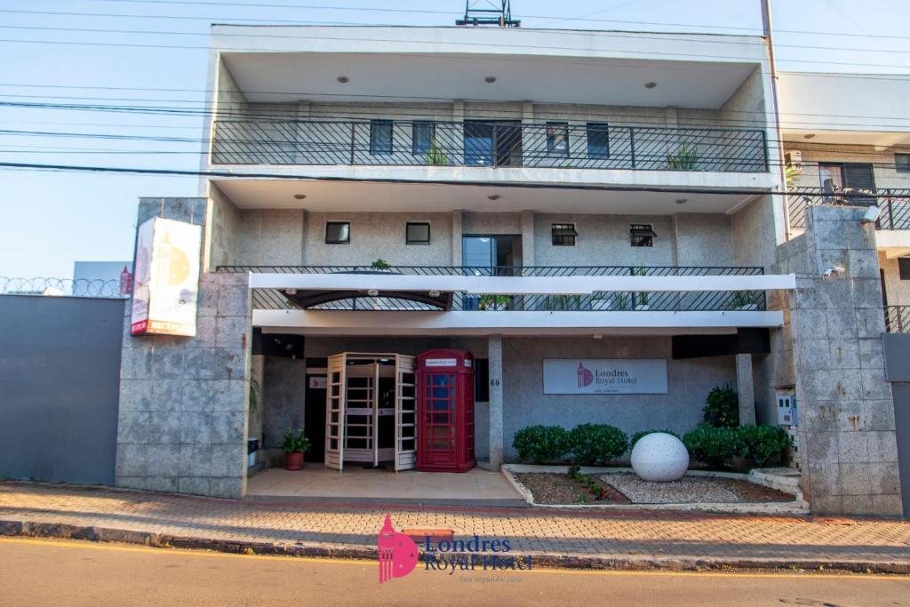 a building with a red phone booth in front of it at Londres Royal Hotel in Londrina