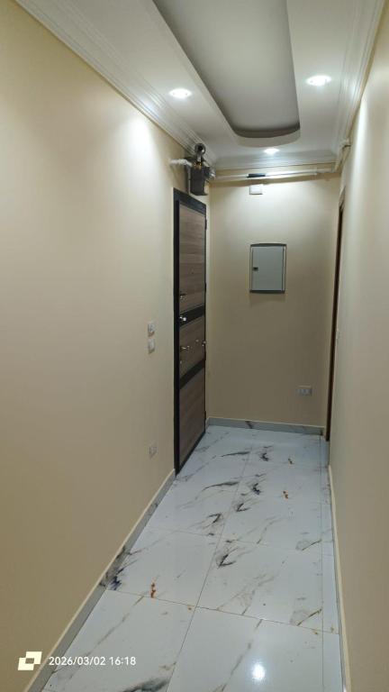 a room with a hallway with a marble floor and a door at Ashraf Residential Complex in Luxor