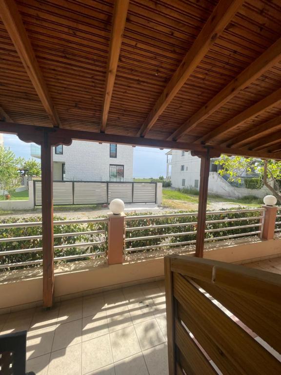 a porch with a wooden roof with a view of a fence at Theodora villas Portaria beach 2 in Paralia Dionysiou