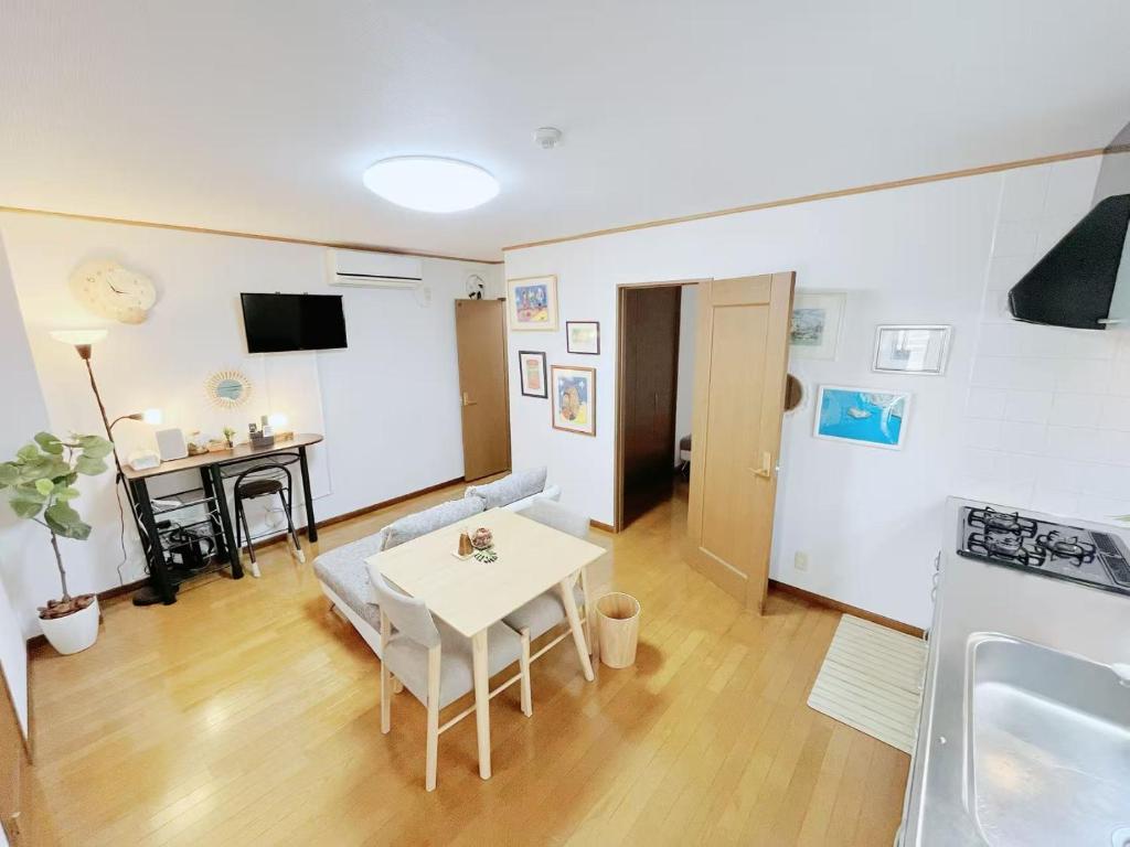 a living room with a white table and a kitchen at LUMI HOUSE 101, 8 minutes to Namba 4 minutes walk to the station self check in in Osaka