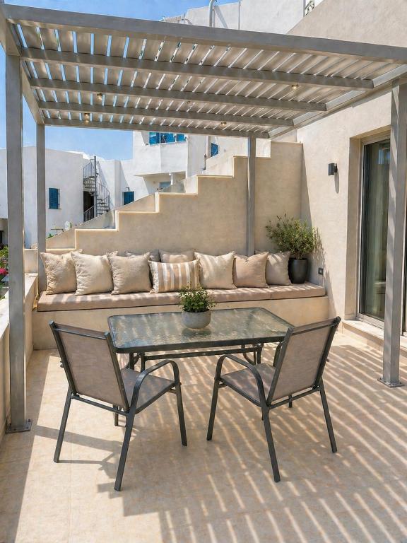 a patio with a table and two chairs and a couch at Memories in Tinos