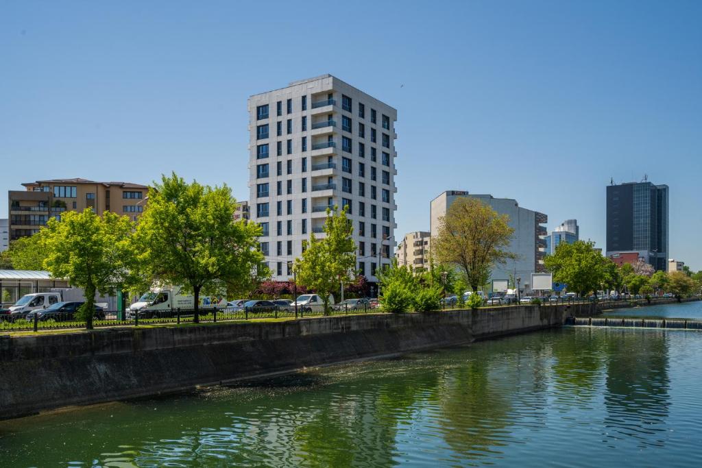 a tall white building next to a river at Studio București in Bucharest