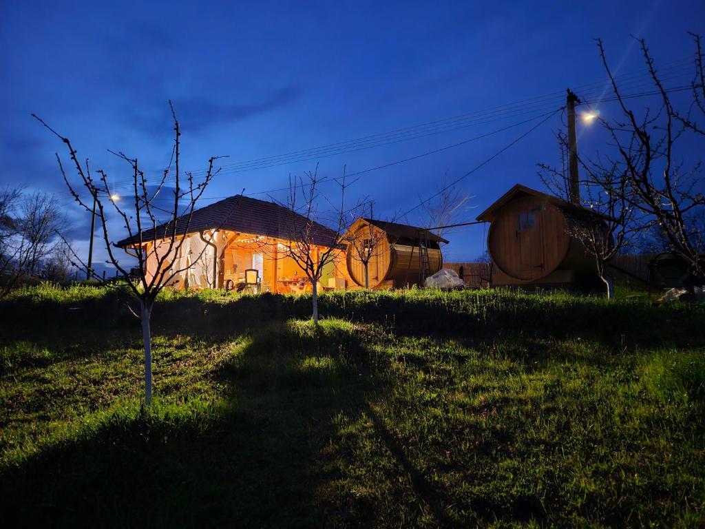 a lit up house in a field at night at Kucica in Lukavac