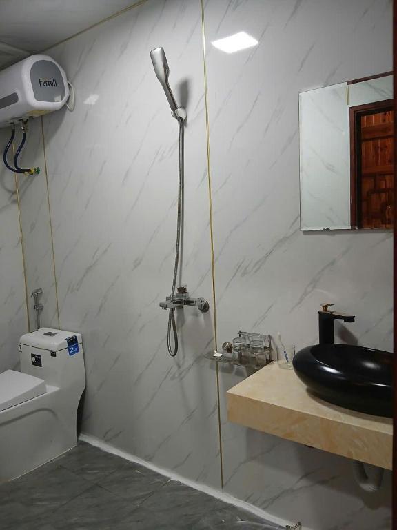 a bathroom with a shower with a sink and a toilet at Sapa Rock Hill Homestay in Tả Van