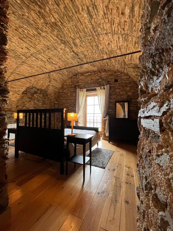 a room with a table and a stone wall at Domaine Santa Petronilla "chapelle" in Rogliano
