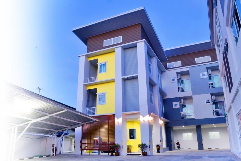 un edificio de color amarillo y blanco en Connect Apartment, en Nakhon Ratchasima