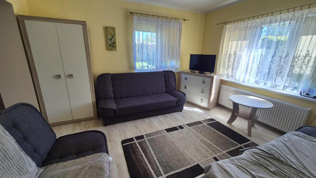 a living room with a couch and a chair and a tv at Apartament u Basi in Gdańsk