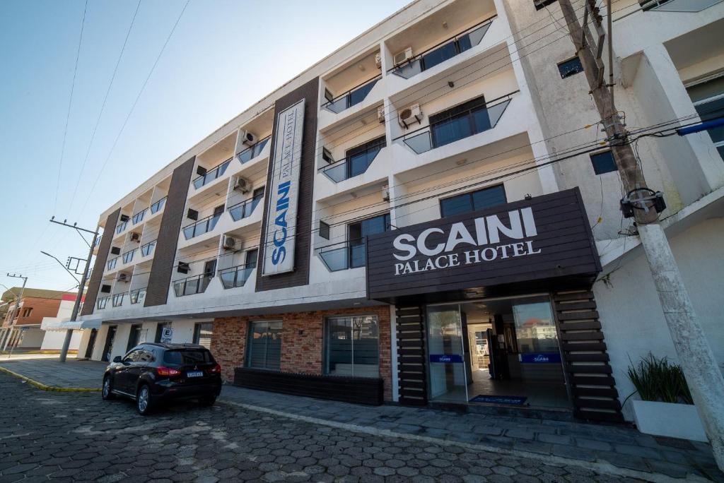 a building with a car parked in front of it at Scaini Palace Hotel in Arroio do Silva
