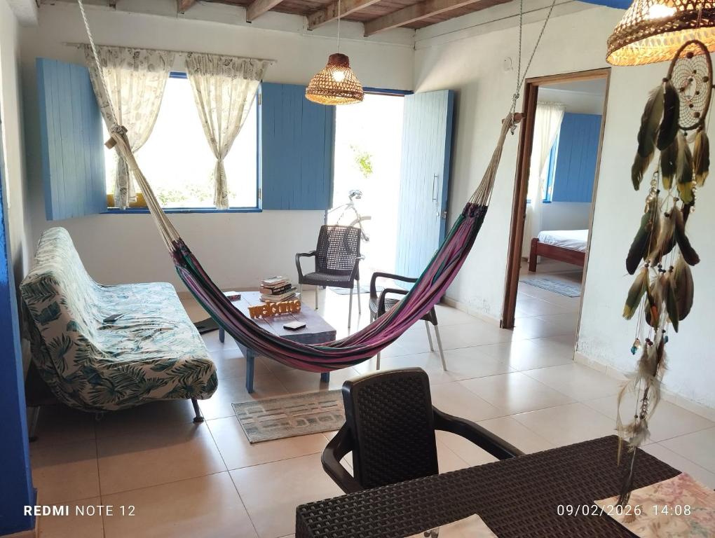 a room with a hammock and a living room at Cabin near the beach in El Valle